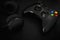 Gamepad and headphones on black background