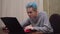 Gamer playing online computer game, winning smiling, on laptop guy blue hair