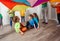 Games with colorful canopy, children sitting under parachute