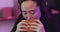 Gaming, fast food and asian woman eating burger and chips while playing live online cyber game on computer in Korea