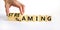 Gaming and streaming symbol. Businessman turns wooden cubes and changes the word gaming to streaming. Beautiful white table white