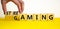 Gaming and streaming symbol. Businessman turns wooden cubes and changes the word gaming to streaming. Beautiful yellow table white