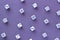 Gaming white dice pattern on purple background in flat lay style.