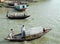 Ganges Delta, Bangladesh: Fishing boats being rowed on the river near a small town