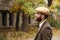 Gangster with a beard staring into the distance standing near an abandoned building. Retro. Outdoors.