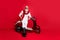 Gangster grandfather man sitting on retro moped waiting party begin wear jumper and trousers isolated red background