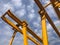 Gantry cranes opposite cloudy sky. Industrial lifting machinery. Hoist, winch