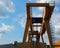 Gantry cranes seen from below against blue sky with clouds