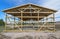 Garage construction in suburbia, USA. Wood, wooden roof truss system. Gray corrugated metal cladding panel on the roof