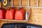 Garage corner with three red plastic fuel cans , staircase and snow plough for atv with wooden wall on background. Petrol gas