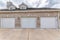 Garage exterior with bricks and three white sectional doors
