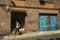 Garage gate on a building facade and woman with cell phone at Caceres