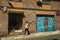 Garage gate on a building facade and woman with cell phone at Caceres