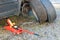 Garage jack, wrench, studded winter tire, and summer tire standing next to car and brake disc exposed.