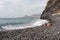 Garajau - Mother holding daughter on idyllic volcanic black stone beach of Praia Garajai, Canico, Madeira island, Portugal