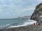 Garajau - Mother holding daughter on idyllic volcanic black stone beach of Praia Garajai, Canico, Madeira island, Portugal