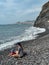 Garajau - Mother holding daughter on idyllic volcanic black stone beach of Praia Garajai, Canico, Madeira island, Portugal