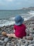 Garajau - Small toddler playing on idyllic volcanic black stone beach of Praia Garajai, Canico, Madeira island, Portugal