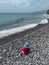 Garajau - Small toddler playing on idyllic volcanic black stone beach of Praia Garajai, Canico, Madeira island, Portugal