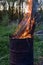 Garbage incineration in rusty metal barrel. burning branches and old grass from the land plot in a barrel. spring cleaning of the