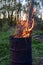 garbage incineration in rusty metal barrel. burning branches and old grass from the land plot in a barrel. spring cleaning of the