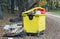 Garbage overflowing container  in a autumn forest