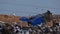 A garbage truck pours garbage out of its body at a landfill. Vulture birds fly over the garbage. Ecological problems