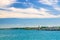 Garda Lake azure turquoise water surface with view of lighthouse on stone pier mole