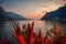 garda lake in the evening with sunset, cliff, mountains and red lighted agaves and plants