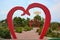 Garden arch in the form of red heart. Installation on the theme of love, weddings in the park of lovers of hearts, Dobroslav,