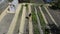 Garden beds top view. A woman cleans furrows with a rake. Vegetable long and even beds and greenhouses at their summer cottage