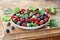 Garden berries in a bowl on wooden table