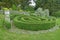 Garden border with large circular topiary hedge