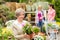 Garden centre senior lady hold potted flower