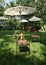 Garden chair on green lawn under the white umbrella