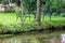 Garden chairs and garden table directly at a little creek and floating river, birch trees and idyllic scene are the perfect travel