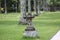 garden decoration with natural stone carvings in the form of lantern holders and rows of coconut trees and green grass