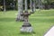 garden decoration with natural stone carvings in the form of lantern holders and rows of coconut trees and green grass