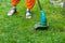 Garden equipment. Young woman mowing the grass with a trimmer.