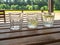 Garden furniture on the terrace of a country house, hotel. Three glasses with a refreshing drink with lemon on a wooden table.
