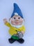 Garden gnome with blue hat and dandelion