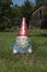 Garden gnome with glittery beard in front of old barn