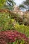 Garden at Great Chalfield Manor near Bradford on Avon, Wiltshire UK, photographed in autumn with red sedum flowers in foreground.