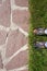 garden path of natural stone, lawn and feet in rubber galoshes