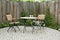 Garden patio with round table and two chairs. Outdoor furniture made of iron and wood material