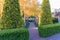 Garden paved path with trimmed Juniper hedges and pavilion
