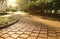 Garden`s curving stone block pathway in the gentle sunlight