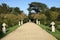 Garden with sculptural urns, sundial, and yew topiary trees