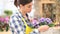 Garden springtime concept, woman florist smiling with white wicker basket flowers of primroses