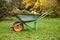 Garden steel robust wheelbarrow with garden garbage. Concept preparing garden for winter season